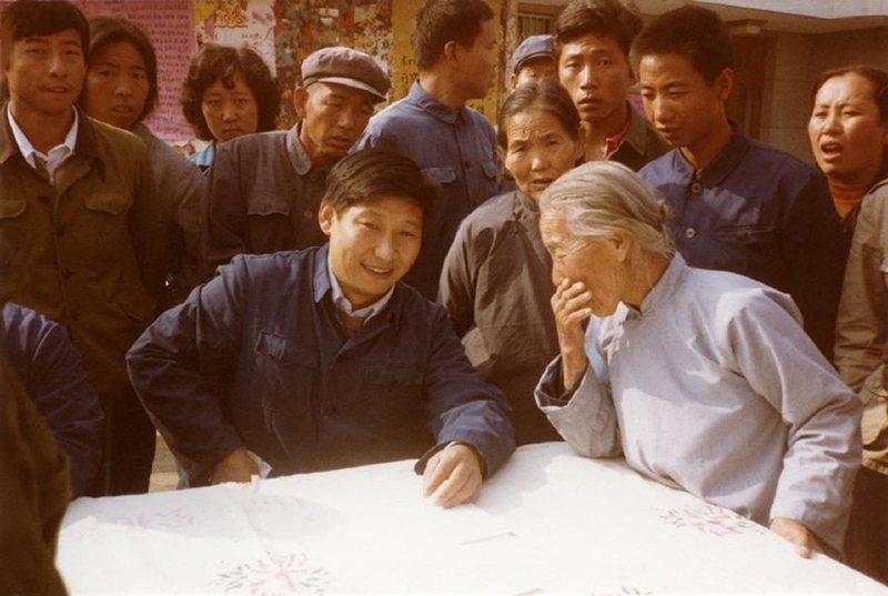 1983年，時(shí)任河北正定縣委書記的習(xí)近平（前排居中），臨時(shí)在大街上擺桌子聽(tīng)取老百姓意見(jiàn)。