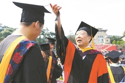 2017年6月22日，李德仁（右一）參加武漢大學(xué)畢業(yè)典禮并為畢業(yè)生撥穗。