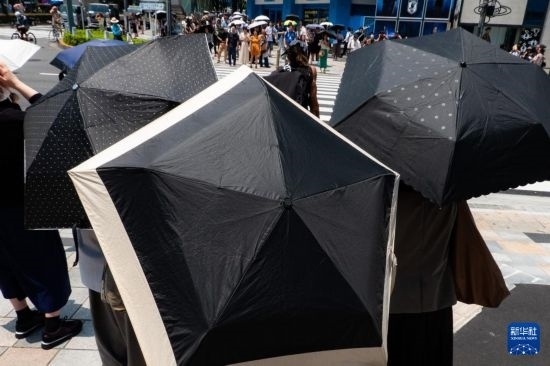 7月4日，人們在日本東京原宿的街道上等待紅綠燈。新華社記者 張笑宇 攝