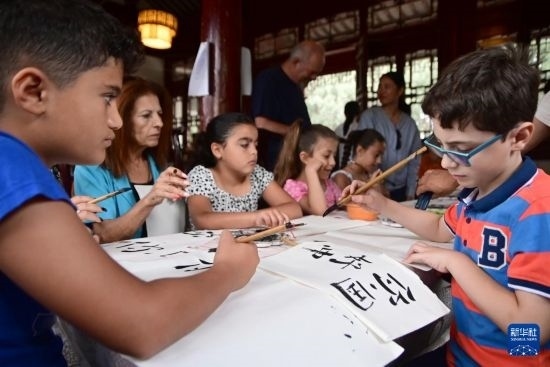 7月4日，在馬耳他桑塔露琪亞市的中國古典園林“靜園”，人們體驗中國書法。新華社發(fā)（喬納森·博格 攝）