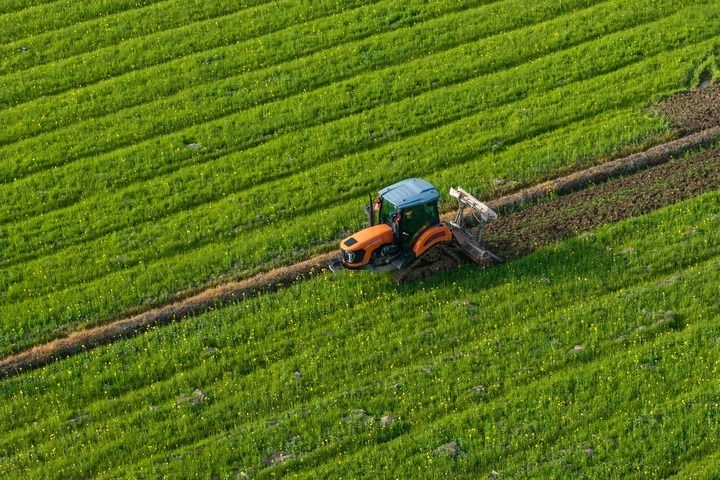 2024年3月19日，在湖南省常德市鼎城區(qū)謝家鋪鎮(zhèn)港中坪村，村民駕駛農(nóng)機(jī)翻耕田地（無人機(jī)照片）。新華社記者 陳思汗 攝