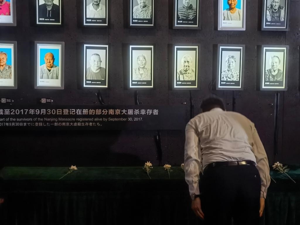 7月18日，人們向離世的南京大屠殺幸存者獻(xiàn)花、鞠躬。新華社記者邱冰清 攝