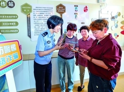 浙江湖州民警指導(dǎo)居民加入湖州“e企安”微信群，實(shí)時(shí)接收反詐信息。新華社發(fā)