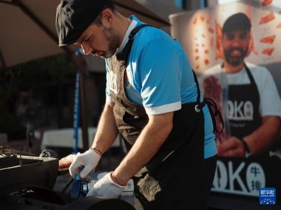 7月19日，在蕪湖古城，馬丁在當(dāng)天舉行的啤酒節(jié)上制作牛排。新華社發(fā)（繆雨晨 攝）