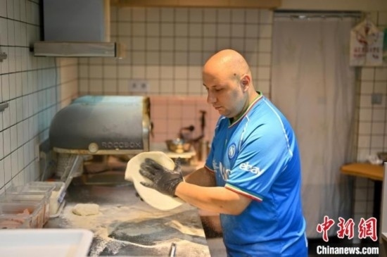 近日，韋榮耀在自家披薩小店內(nèi)忙活。俞靖 攝