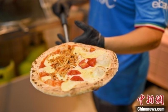 近日，韋榮耀展示他制作的“老友味”披薩。 俞靖 攝