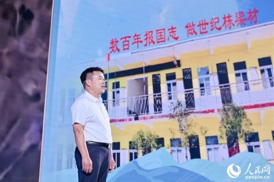 張玉滾分享用一根扁擔(dān)送孩子們走出大山的故事。人民網(wǎng)攝