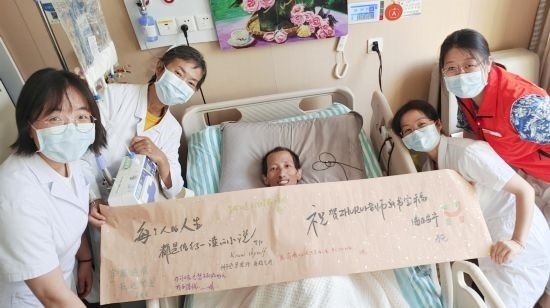 7月26日，海淀醫(yī)院安寧療護(hù)科醫(yī)護(hù)團(tuán)隊為朱銳送來一條寫滿祝福的橫幅。（受訪者供圖）