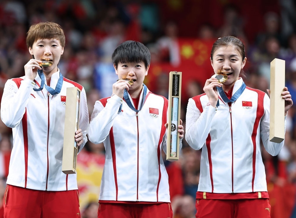冠軍中國隊選手王曼昱、孫穎莎、陳夢（從左至右）在巴黎奧運會乒乓球女子團體頒獎儀式上（2024年8月10日攝）。新華社記者 王東震 攝