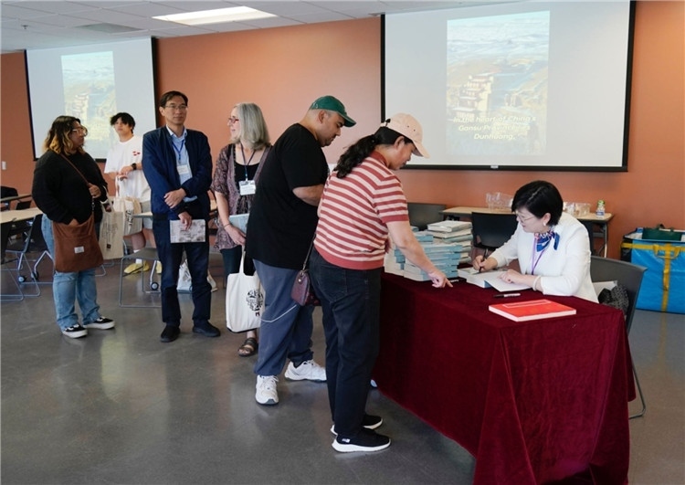 作者顧春芳在活動現(xiàn)場簽名贈書。羅先勇攝