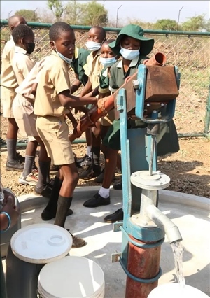 △2021年11月，在津巴布韋南馬塔貝萊蘭省省會關(guān)達的塞農(nóng)多小學(xué)，學(xué)生從中國援建水井里打水。