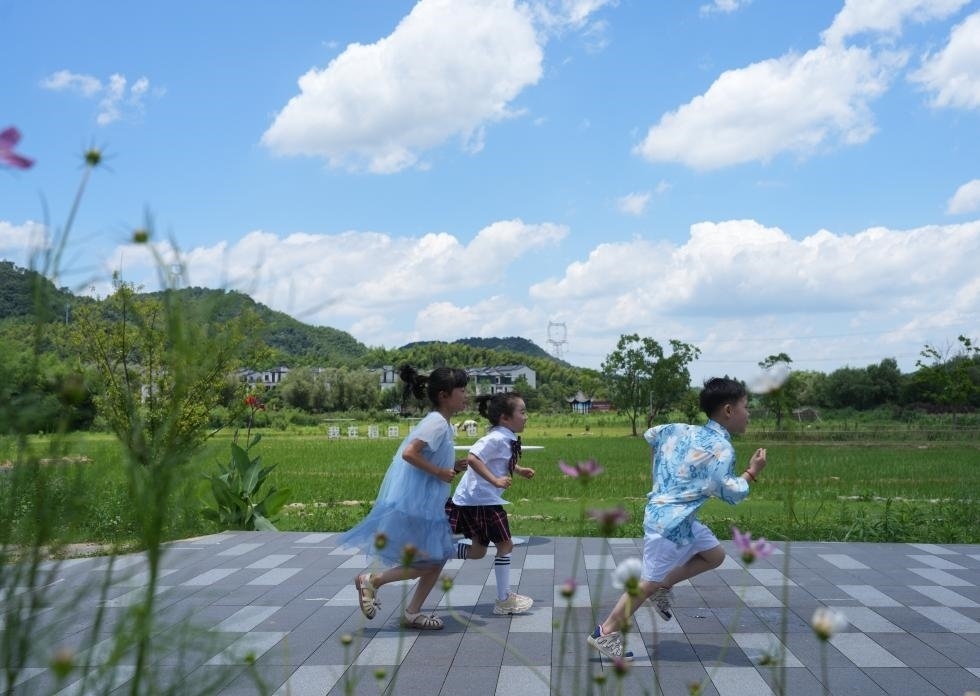 兒童在余姚市梁弄鎮(zhèn)的田野間奔跑（7月3日攝）。新華社記者翁忻旸 攝