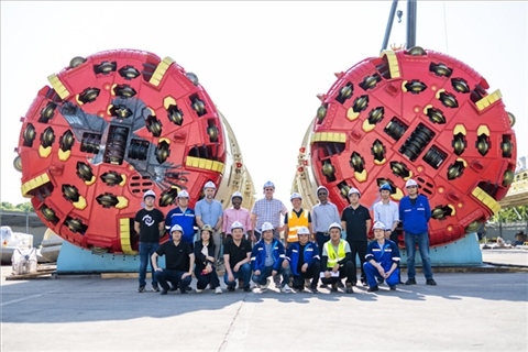 中外員工在盾構(gòu)機(jī)前合影。中國電建供圖