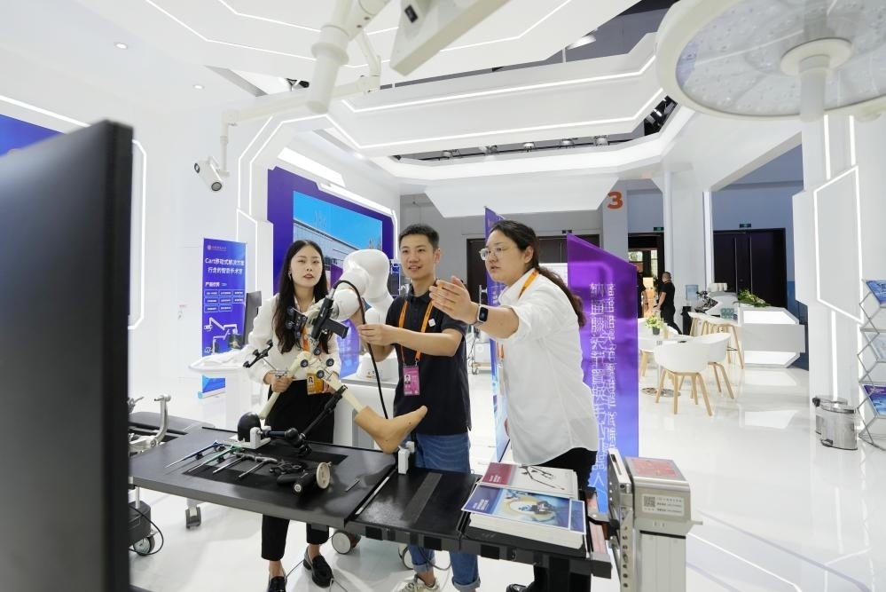 9月11日，一位媒體記者（中）在2024年服貿(mào)會國家會議中心會場體驗北京納通科技集團有限公司的膝關(guān)節(jié)置換手術(shù)機器人。新華社記者鞠煥宗 攝