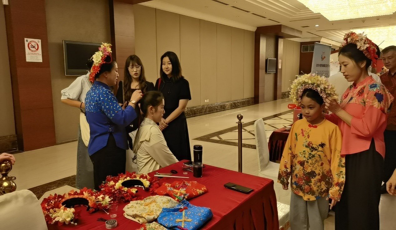 阿拉扎大學(xué)孔子學(xué)院志愿者老師向傳承人學(xué)習(xí)簪花圍。阿拉扎大學(xué)孔子學(xué)院供圖