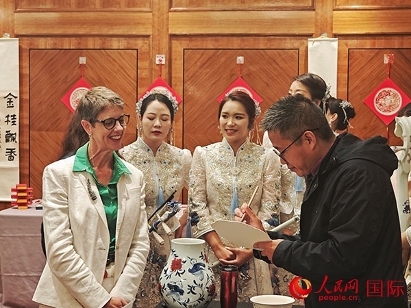 現(xiàn)場的非遺傳承人為英國觀眾展示畫技。人民網(wǎng)記者 邢雪攝