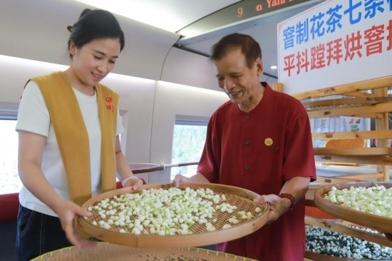 10月1日，福州市茉莉花茶窨制工藝代表性傳承人張子建與旅客在G1634次列車上制作茉莉花茶。新華社記者周義 攝