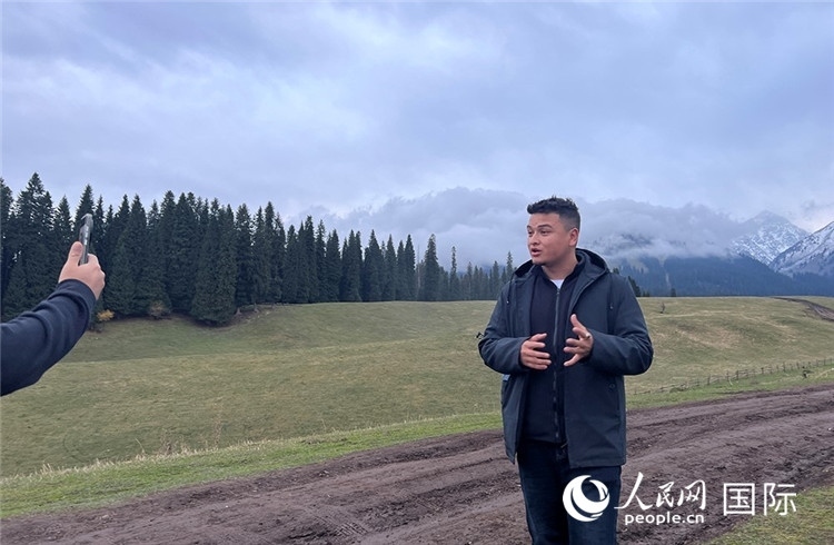 在庫爾德寧，吾買爾江被雪山美景震撼，即興錄制了短視頻作品。人民網(wǎng)記者曾書柔攝