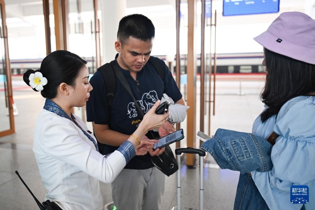 10月12日，在老撾萬(wàn)象中老鐵路萬(wàn)象站，工作人員檢驗(yàn)乘客車票。新華社記者 程一恒 攝