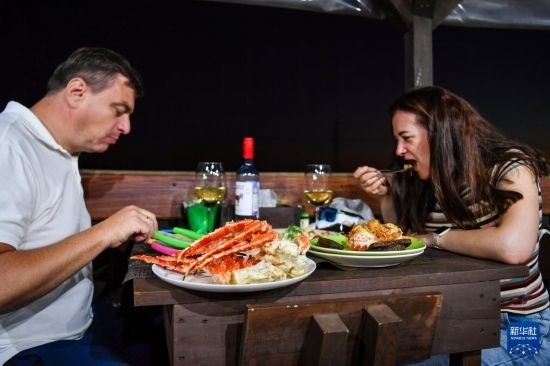 9月2日，食客們在俄羅斯符拉迪沃斯托克的一家餐館品嘗帝王蟹。新華社記者 曹陽 攝