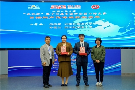 外交部亞洲司參贊張梅（右一）、中聯(lián)部副局長沈建國（左一）為獲得日語同傳組二等獎(jiǎng)的北京外國語大學(xué)岳忠昊、四川外國語大學(xué)樸雪蘭頒獎(jiǎng)（主辦方提供）