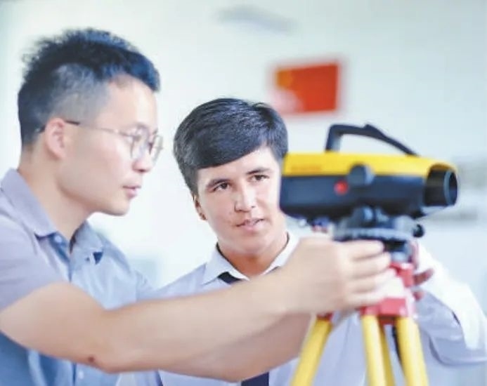 在塔吉克斯坦首都杜尚別的魯班工坊，來自天津城市建設(shè)管理職業(yè)技術(shù)學(xué)院的老師（左）為當(dāng)?shù)貙W(xué)生提供指導(dǎo)。新華社記者 鄭開君 攝