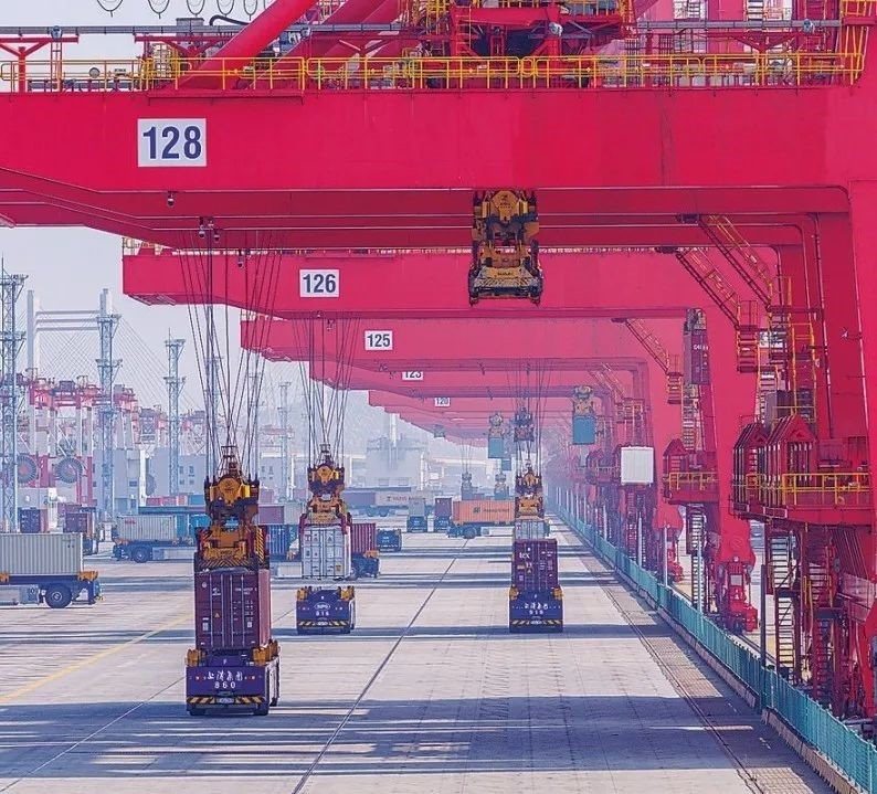 共建“一帶一路”國家在工作制度對接、技術(shù)標(biāo)準(zhǔn)協(xié)調(diào)、檢驗(yàn)結(jié)果互認(rèn)等方面強(qiáng)化合作、統(tǒng)一標(biāo)準(zhǔn)，貿(mào)易自由化便利化水平不斷提升。上海洋山港海關(guān)對接共建國家進(jìn)出口貨物相關(guān)標(biāo)準(zhǔn)，推動通關(guān)一體化方式申報(bào)，提升通關(guān)效率。圖為無人駕駛的全自動導(dǎo)引車在洋山港穿梭往來，搬運(yùn)集裝箱。王初 攝