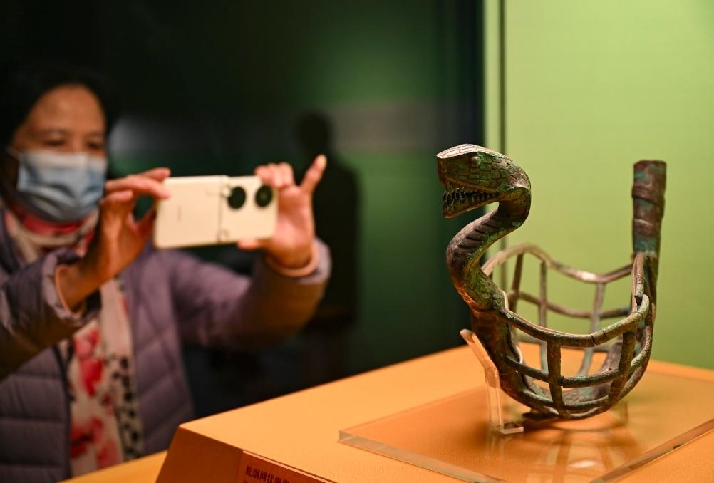 1月14日，觀眾在上海博物館蛇年迎春展拍攝展品蛇綱網(wǎng)狀銅器。新華社發(fā)（陳浩明攝）