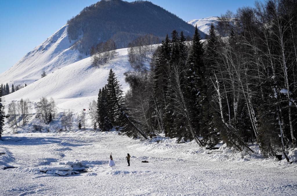 2024年2月5日，兩名游客在新疆阿勒泰地區(qū)布爾津縣禾木村拍照。新華社記者 馬鍇 攝