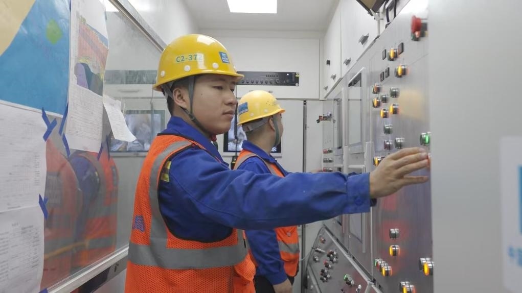 盾構司機何曉波在駕駛室內(nèi)調(diào)試盾構機參數(shù)。（劉芬攝）