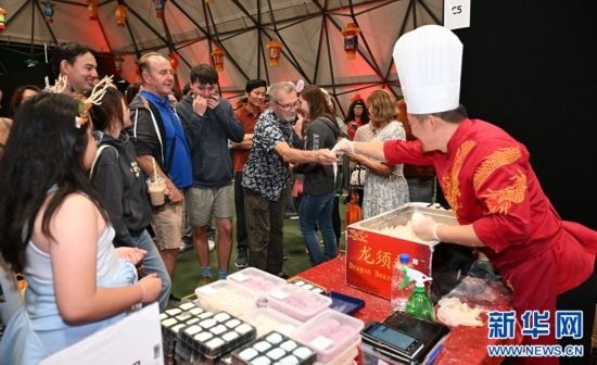 圖為游客在燈節(jié)現(xiàn)場(chǎng)購(gòu)買小吃。（圖片由奧克蘭中國(guó)文化中心提供）