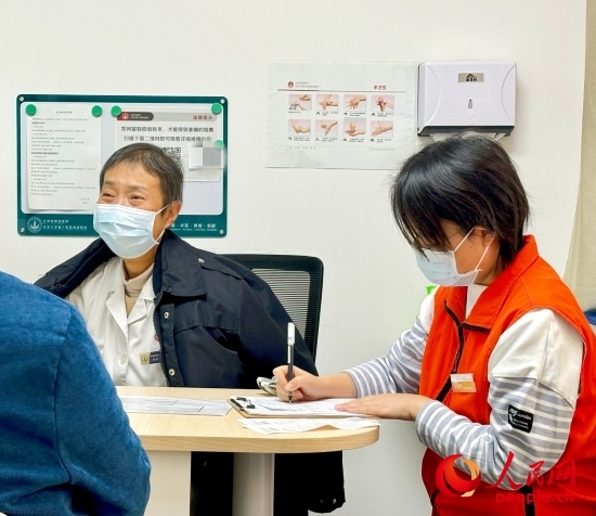 秦苑（中）接診患者。人民網(wǎng)記者 金慧慧攝