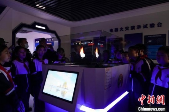 圖為學(xué)生們參觀道里區(qū)消防救援大隊消防科普體驗館內(nèi)幻影成像燃燒三要素實驗臺。中新社記者 趙宇航 攝