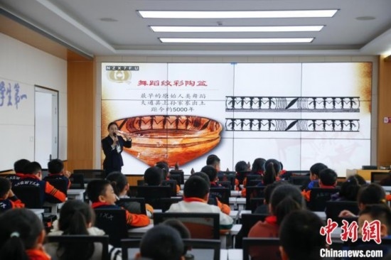 圖為學(xué)生在“國寶音樂會(huì)”社教課中了解舞蹈紋彩陶盆。中新社記者 馬銘言 攝