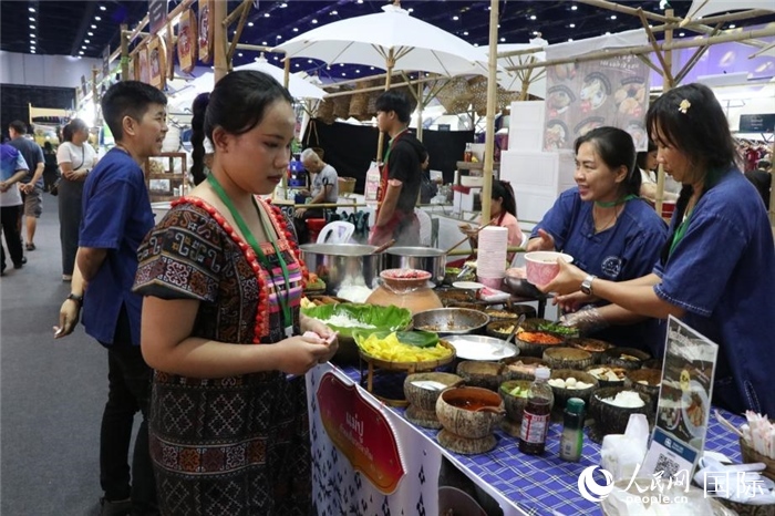 游客在攤位前購買特色美食。朱瀟逸攝