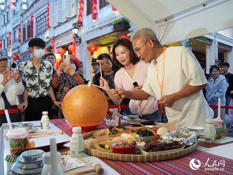 嘉賓品嘗海南傳統(tǒng)美食“煎堆”。人民網(wǎng)記者 張力洋攝