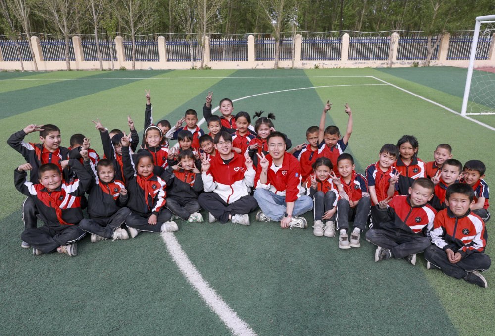 4月23日，在新疆克州阿圖什市哈拉峻鄉(xiāng)謝依特小學，支教教師王俊文（中左）、李軻凡（中右）和學生在一起。