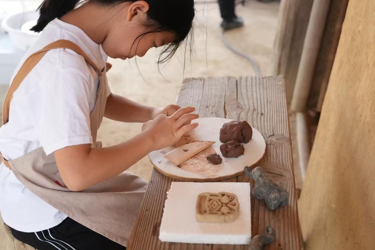 游客制作良渚特色陶藝品。良渚博物院供圖