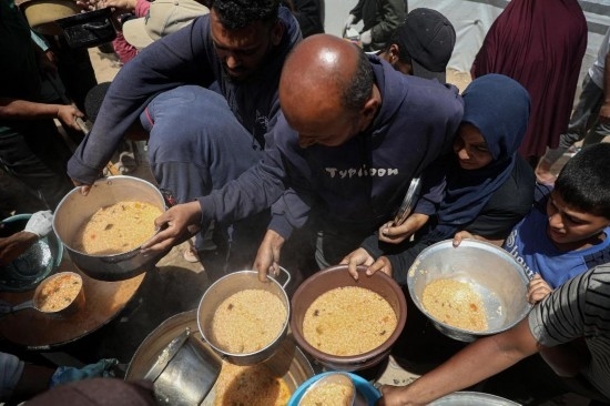 5月28日，人們?cè)诩由吵俏鞑康纳程犭y民營(yíng)領(lǐng)取救助食物。新華社發(fā)（里澤克·阿卜杜勒賈瓦德攝）